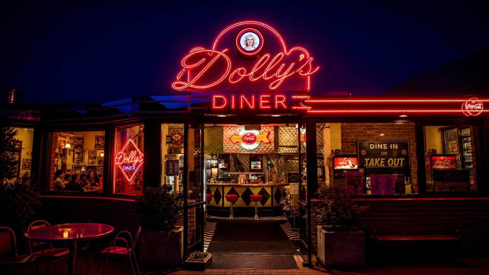 A diner's neon sign glowing at dusk